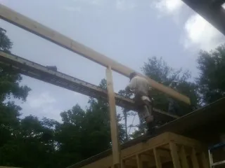 Carpenter setting a ridge beam over a new addition frame — Ice Dam Removal by Roofing Brothers in Rock Valley