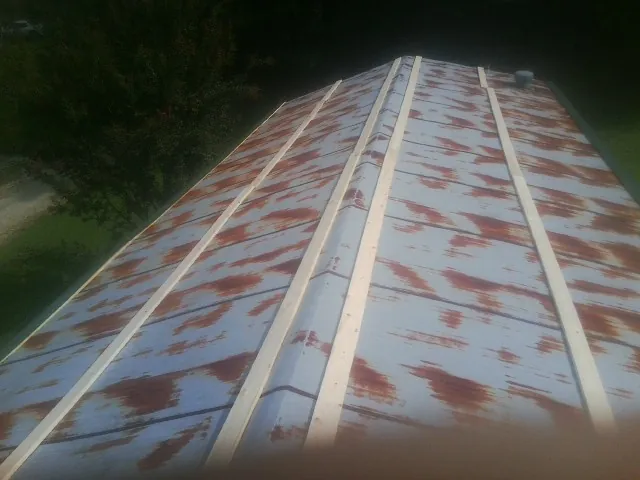 Rusted metal roof panels with new wood purlins before replacement — Storm Damage Roof Repair in Rock Valley by Roofing Brothers