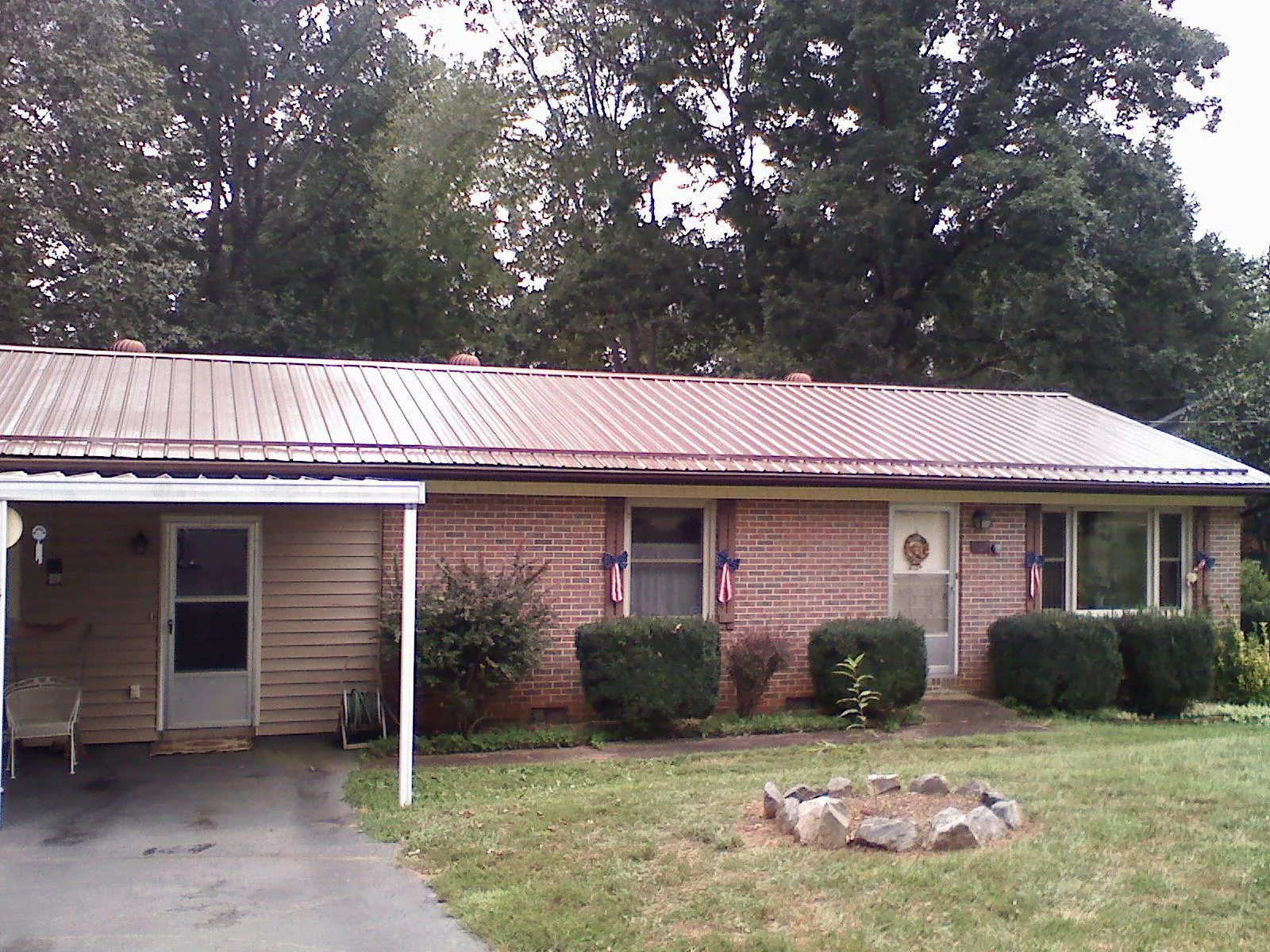 Bronze metal roof and carport on a brick ranch home — Roof Repair work by our crew in Rock Valley