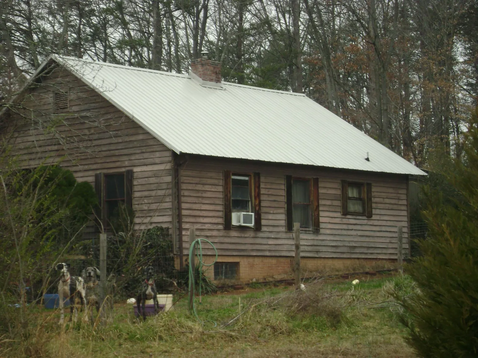 White metal roof on an old wood sided farmhouse, from a Metal Roof Installation job in Rock Valley